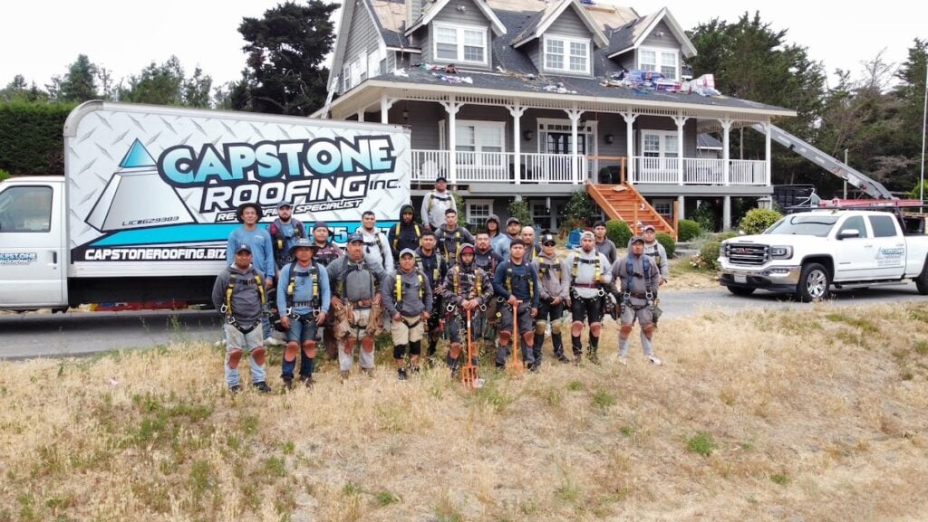 Capstone roofing team in front of branded van