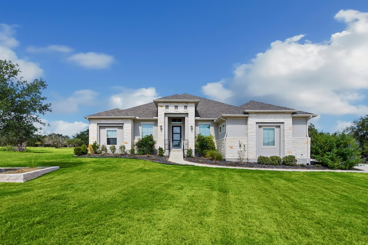 front of a large home with a green lawn