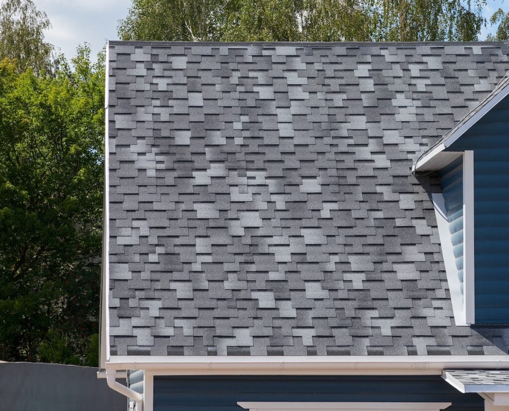 The roof of the house lined with gray architectural shingles