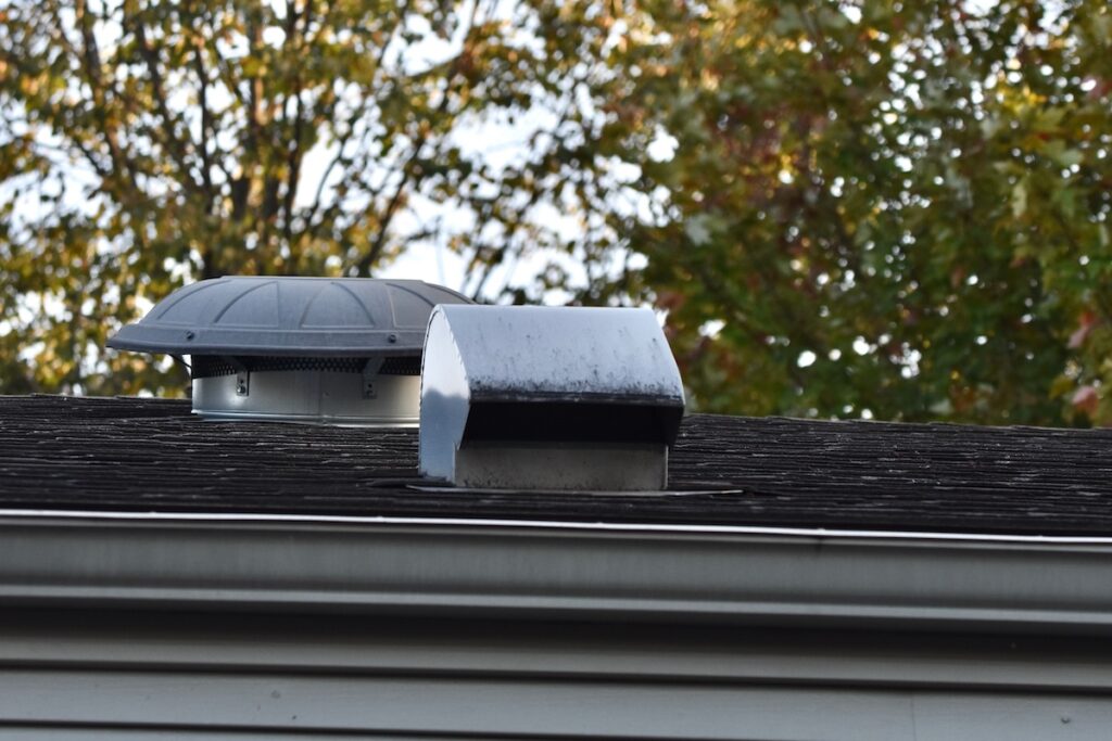 attic vent and stove vent louver on roof of house