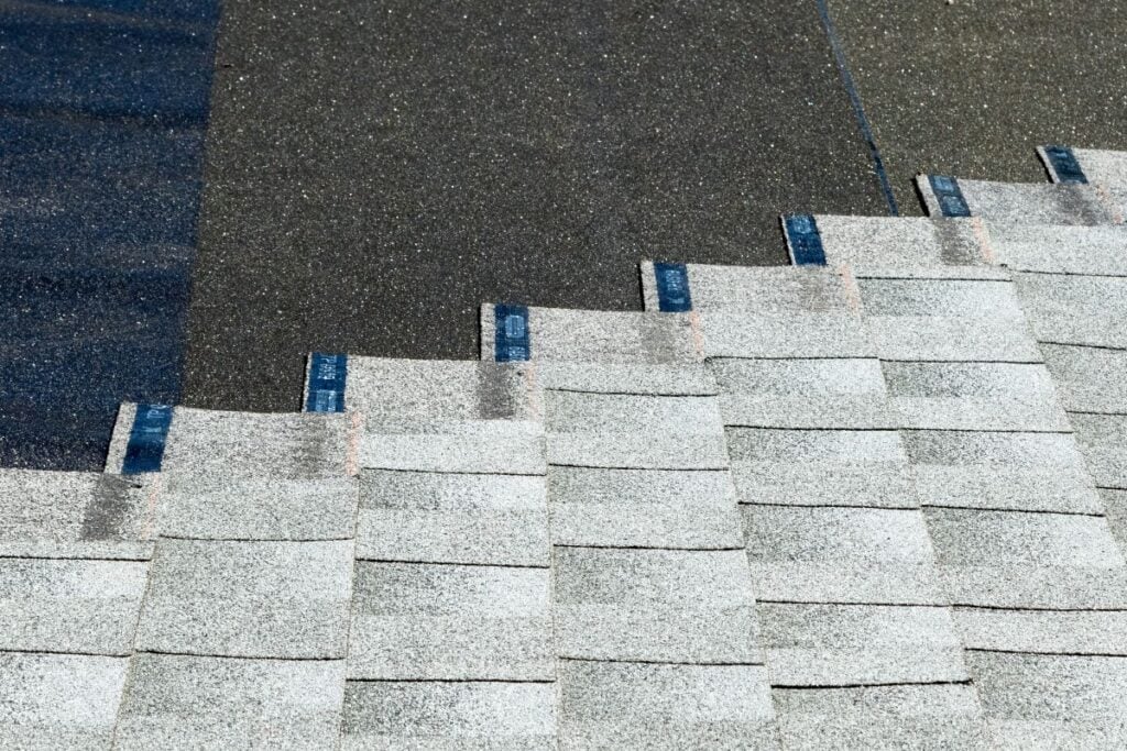 asphalt shingles being installed on top of roof underlayment