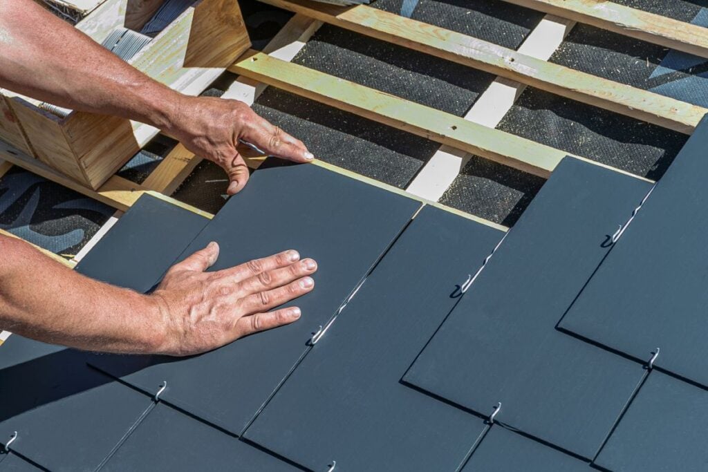 roofer hands installing slate tile roof
