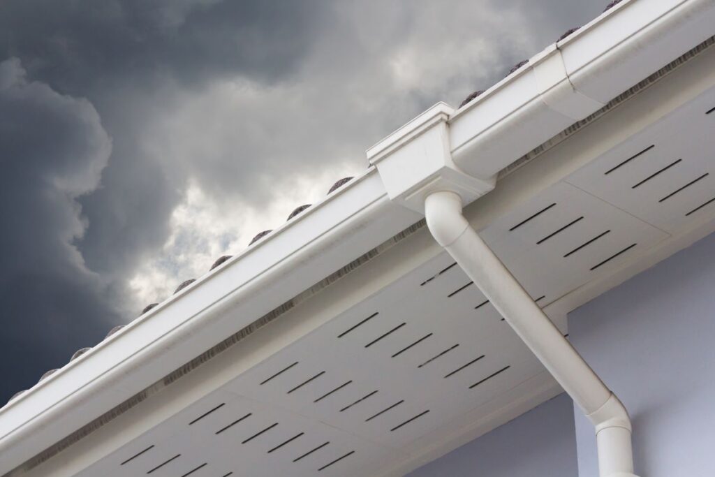 white plastic rain gutter and dark sky