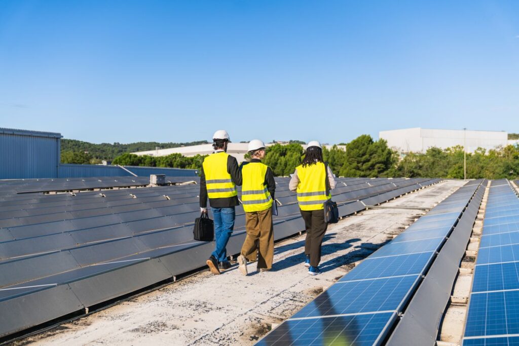 commercial roof inspection three workers inspecting building with solar panels