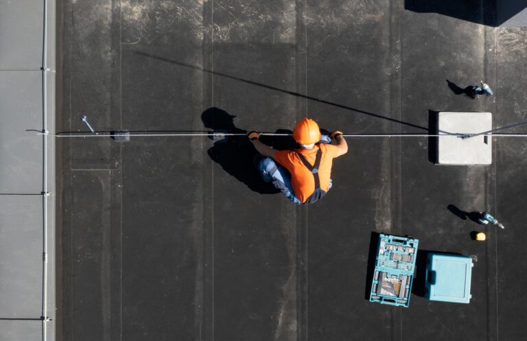 commercial roof inspection worker using orange helmet inspeting black EPDM