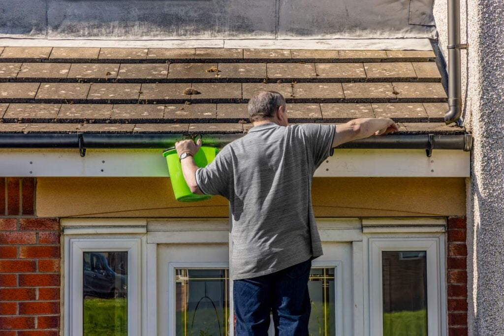 how to remove moss from roof worker cleaning moss