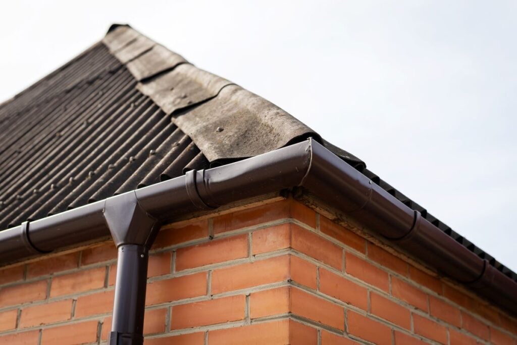 Focus on gutter connection at brick building corner
