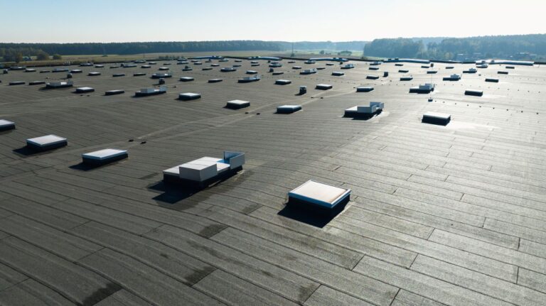 Large industrial flat roof with skylights on modern warehouse building